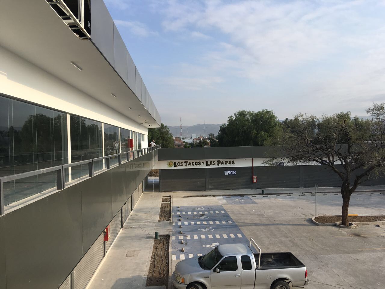 Fachada lateral de Europlaza con columnas y acceso peatonal, proyecto comercial Fer Et Ciment el Bajío